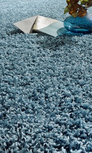 Shaggy Teppichboden blau Struktur mit blauer Vase mit Pflanze und Papier